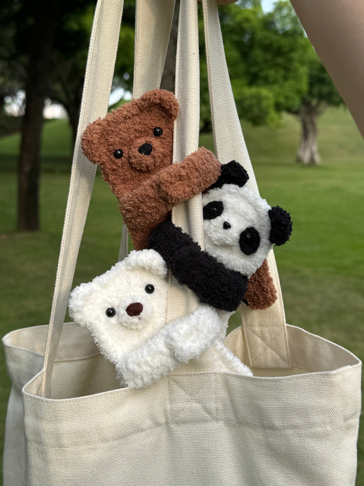 Handmade crochet bear bag charm peeking from a tote bag, featuring adorable details and a soft, textured design, perfect for adding a cute touch to your accessories